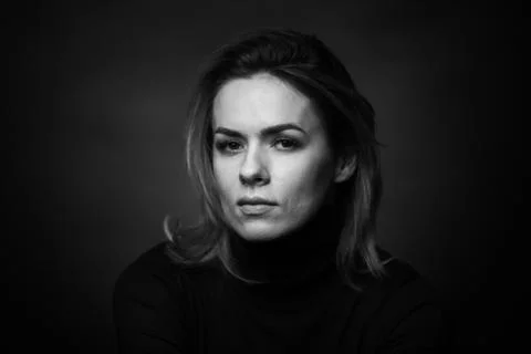 Dramatic black and white portrait of a beautiful woman on a dark background Stock Photos