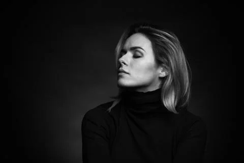 Dramatic black and white portrait of a beautiful woman on a dark background Stock Photos