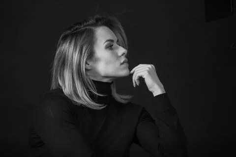 Dramatic black and white portrait of a beautiful woman on a dark background Stock Photos