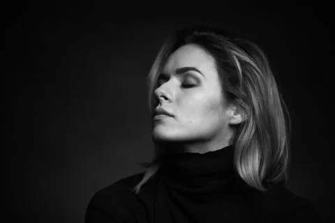 Dramatic black and white portrait of a beautiful woman on a dark background Stock Photos