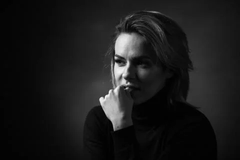 Dramatic black and white portrait of a beautiful woman on a dark background Stock Photos