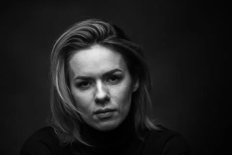 Dramatic black and white portrait of a beautiful woman on a dark background Stock Photos