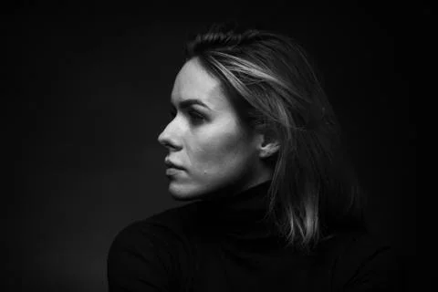 Dramatic black and white portrait of a beautiful woman on a dark background Stock Photos