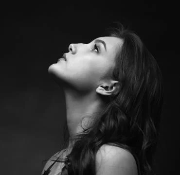 Dramatic black and white portrait of a beautiful girl on a dark background Stock Photos