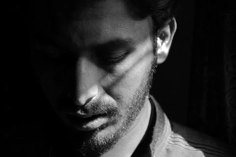 Dramatic Black and White Portrait of a Young Man with Half Face Shadow Lighting Stock Photos