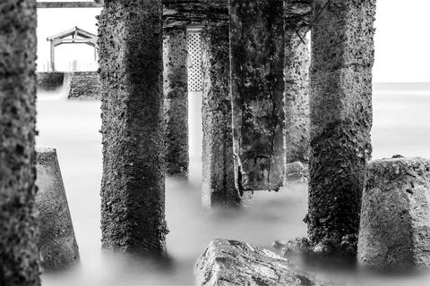 Dramatic Black and White View of the Sea Under a Bridge. Picturesque Coasta.. Stock Photos