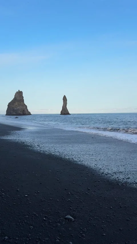 Dramatic black sand beach of Reynisfjara with basalt columns and sea stacks Video stock 332753115