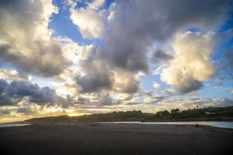 Dramatic Black Sand Beach Under Towering Sunset Clouds Foto stock