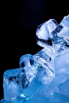 Dramatic blue ice cubes on dark black background with luminous translucent .. Фото