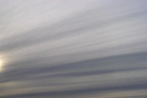 Dramatic blue sky and warm light clouds at sunrise time. Stock Photos
