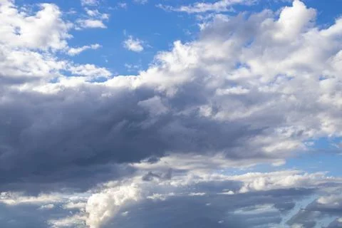 Dramatic blue sky and warm light clouds at sunrise time. Stock Photos