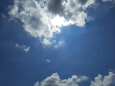 Dramatic Blue Sky with Bright White Clouds and Sunlight. Stock Photos