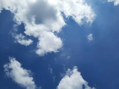 Dramatic Blue Sky with Bright White Clouds and Sunlight. Stock Photos