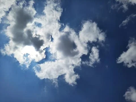 Dramatic Blue Sky with Bright White Clouds and Sunlight. Stock Photos