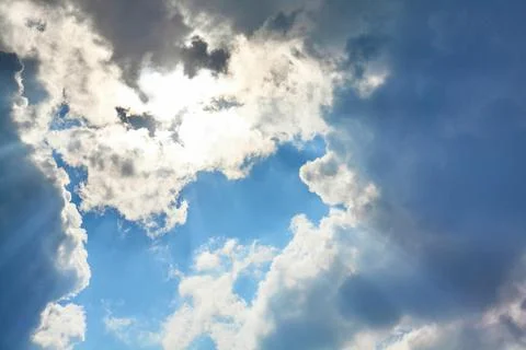 Dramatic blue sky with clouds and sun rays breaking through texture Stock Photos