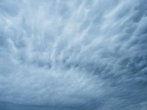 Dramatic blue sky with clouds. Spooky abstract background texture. Stock Photos