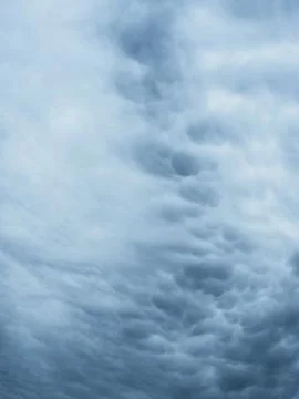 Dramatic blue sky with clouds. Spooky abstract background texture. Stock Photos