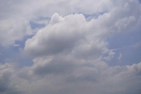 Dramatic blue sky with fluffy white cumulus clouds against sunlight backdrop Stock Photos