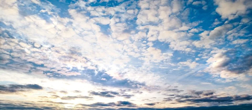 Dramatic blue sky with glowing clouds at sunset natural cloudscape background Stock Photos