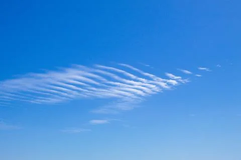 Dramatic blue sky landscape with small gusty cloud Stock Photos