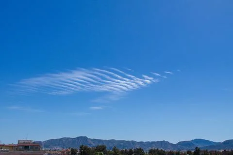 Dramatic blue sky landscape with small gusty cloud Stock Photos