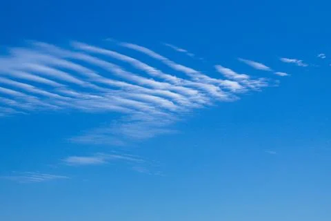 Dramatic blue sky landscape with small gusty cloud Stock Photos