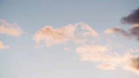 Dramatic blue sky with pink fluffy clouds turning orange then darker. Gathering Stock Footage 128900414