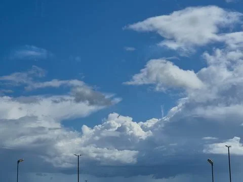 Dramatic blue sky with scattered clouds and city streetlights Stock Photos