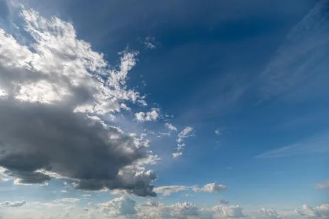 Dramatic blue sky with scattered cumulus clouds at horizon Stock Photos