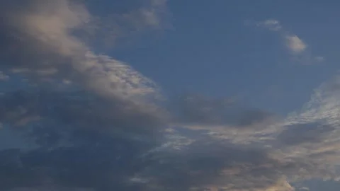 Dramatic Blue Sky with Scattered White and Golden Sunlit Clouds Stock Footage 340186476