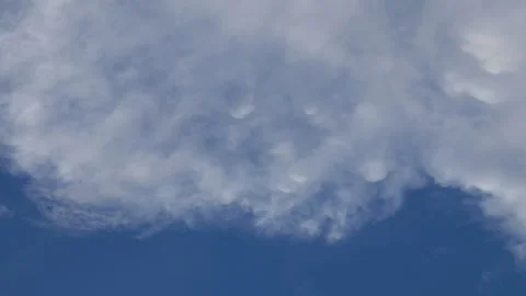 Dramatic Blue Sky with Scattered White and Golden Sunlit Clouds Stock Footage 340380719