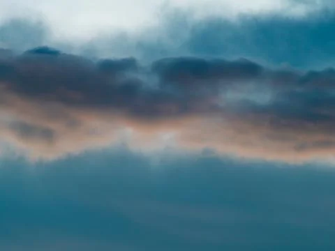 Dramatic Blue-Teal Storm Clouds with Warm Sunset Light Peeking Through Stock Photos