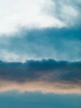 Dramatic Blue-Teal Storm Clouds with Warm Sunset Light Peeking Through Stock Photos