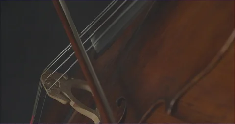 Dramatic bowing of cello strings at symphony close up Stock Footage 127580682