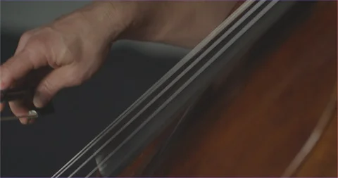 Dramatic bowing of cello strings at symphony close up Stock Footage 127580762