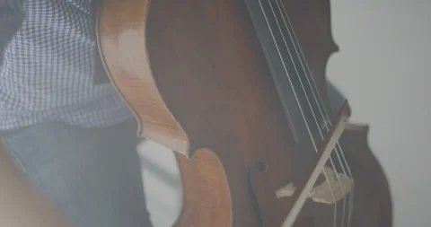 Dramatic bowing of cello strings at symphony close up Stock Footage 127581107