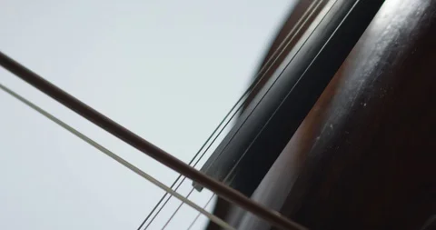 Dramatic bowing of cello strings at symphony close up Stock Footage 127581317