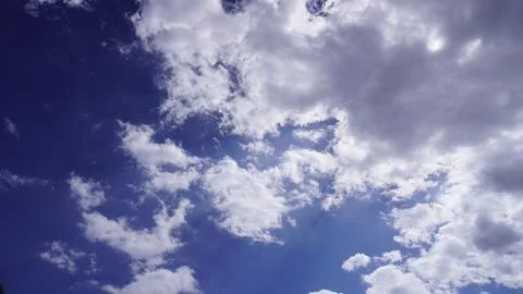 Dramatic bright blue sky filled with billowing white and gray clouds, vast. Stock Photos