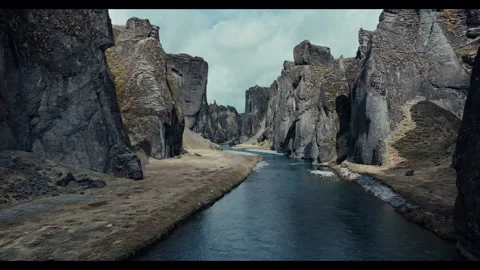 Dramatic Canyon Landscape with Jagged Rock Formations and Calm River Stock Footage 297391962