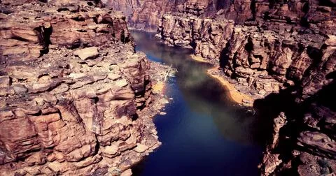 Dramatic canyon landscape with still waters reflecting rocky cliffs Illustrazione stock