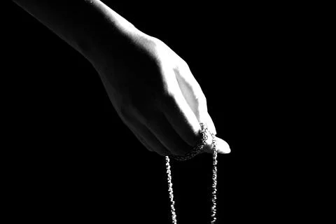 A Dramatic Capture of a Hand Holding a Delicate Piece of Jewelry in Black and Stock Photos
