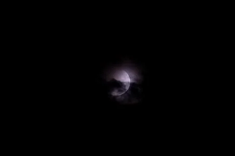 A dramatic capture of the lunar eclipse piercing through the midnight sky Stock Photos