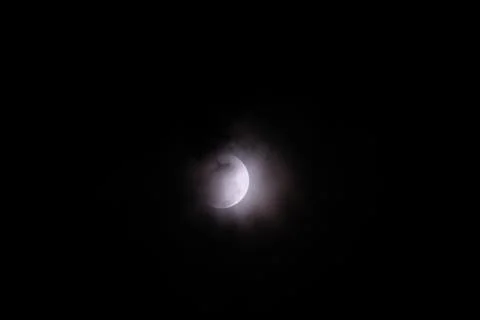 A dramatic capture of the lunar eclipse piercing through the midnight sky Stock Photos
