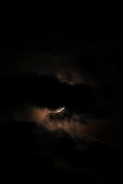 A dramatic capture of the lunar eclipse piercing through the midnight sky Stock Photos