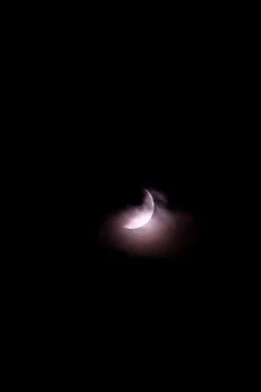 A dramatic capture of the lunar eclipse piercing through the midnight sky Stock Photos