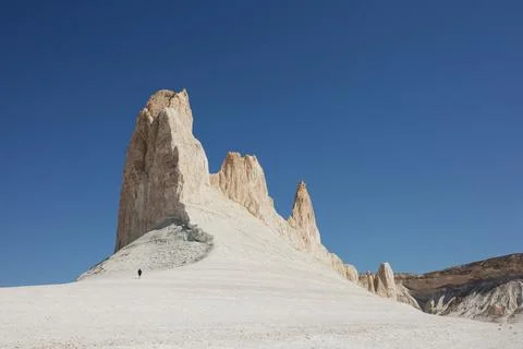 Dramatic chalk cliffs and pinnacles with tiny hiker for scale Stock Photos