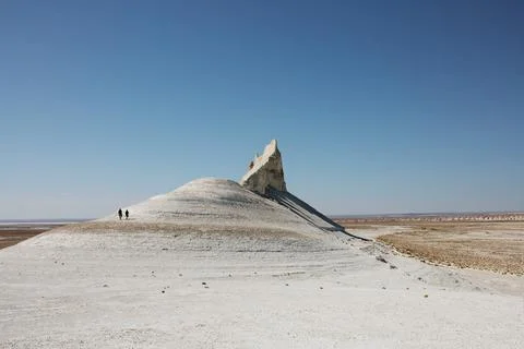 Dramatic chalk cliffs and pinnacles with tiny hikers for scale Stock Photos