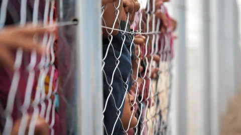 Dramatic children's hands through the fence in a refugee camp. Mosul, Iraq Vídeo Stock 158379954