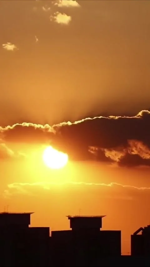 Dramatic City Sunset Silhouette with Bright Sunburst and Clouds Видео 334585040