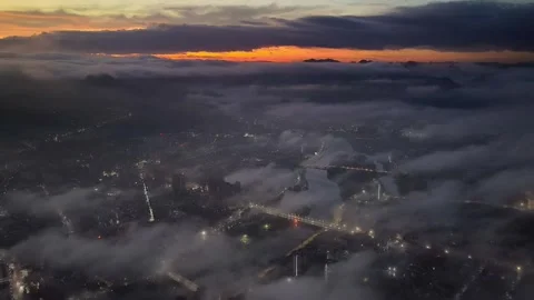 Dramatic Cityscape Sunrise Above the Clouds and Mist with Glowing Street Lights Stock Footage 319725689